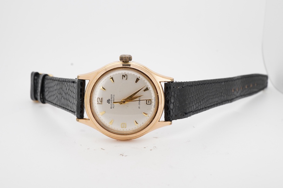 A gentleman's steel and gold plated Bucherer automatic wrist watch, with baton and quarterly Arabic numerals, case diameter 34mm, on an associated leather strap.